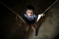 A Rohingya refugee child reacts to the camera while sitting on a cradle at the Balikhali camp in Cox's Bazar, Bangladesh, November 14, 2018. REUTERS/Mohammad Ponir Hossain