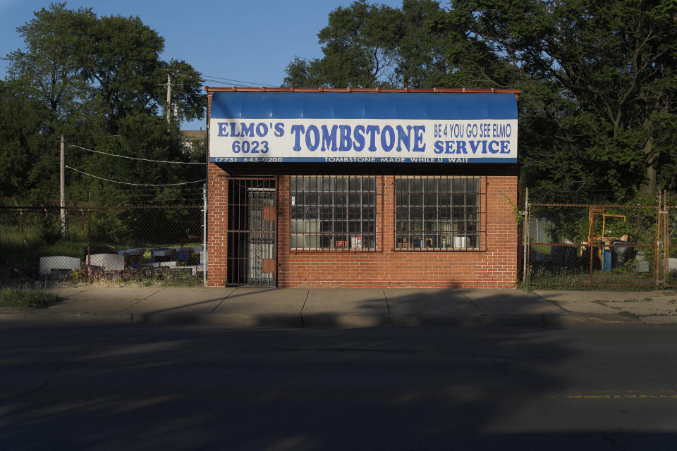 In this Sunday, June 7, 2020 photo, the afternoon sun casts shadows across State Street in front of Elmo's Tombstone Service on the Chicago's Southside. The slogan "Be 4 You Go, See Elmo" was coined by original Elmo's Tombstone Service owner, Robert Williams, graces the awning of the small shop now owned by Hosea Knox. (AP Photo/Charles Rex Arbogast)