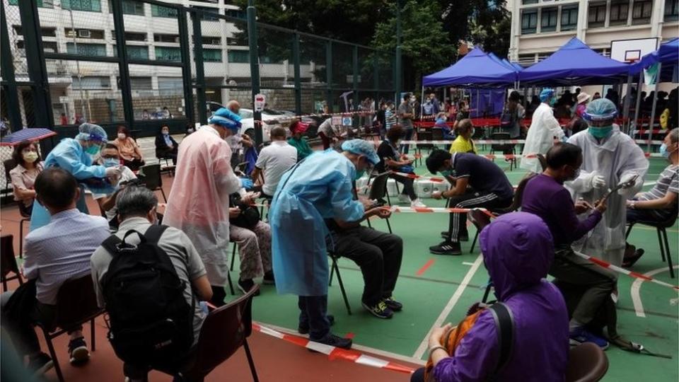 Medical workers in protective suits attend to people at a makeshift community testing centre for the coronavirus disease (COVID-19), in Hong Kong"s Yau Tsim Mong district, China November 24, 2020.