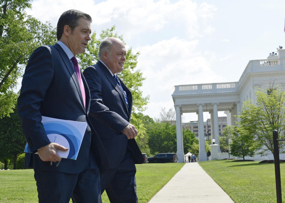 FILE - In this May 11, 2018, file photo, Association of Global Automakers President and Chief Executive Officer John Bozzella, left, and Ford Motor Company Chief Executive Officer Jim Hackett, right, arrive for a meeting with President Donald Trump at the White House in Washington. At a board meeting Tuesday, Dec. 1, 2020, the Alliance for Automotive Innovation, a big industry trade association, recognized that change is coming. Alliance CEO John Bozzella said automakers are committed to working with the Biden administration, which will renew the fight against climate change and likely will undo pollution and gas mileage rollbacks made by President Donald Trump. (AP Photo/Susan Walsh, File)