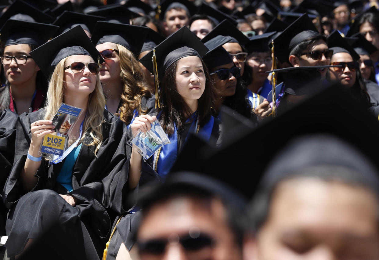 Graduates listen to U.S. President Barack Obama (not pictured) talk during the commencement ceremony for the University of California, Irvine at Angels Stadium in Anaheim, California June 14, 2014. REUTERS/Larry Downing (UNITED STATES - Tags: POLITICS EDUCATION)