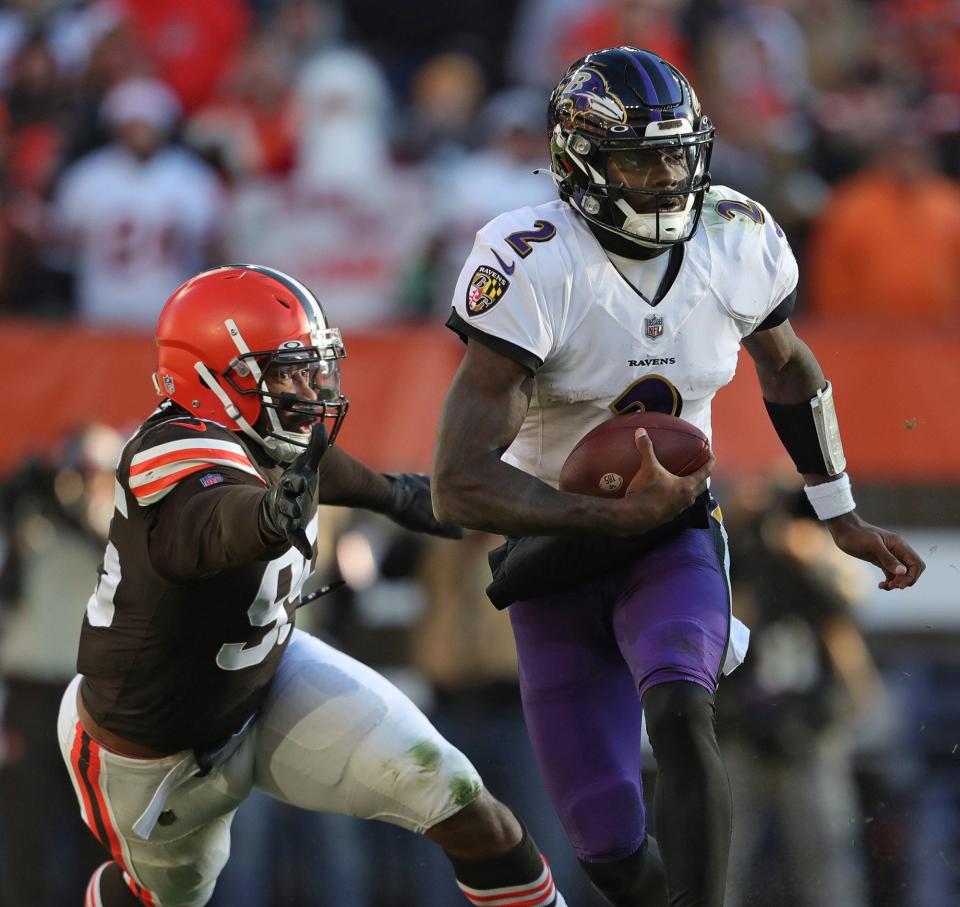 Baltimore Ravens quarterback Tyler Huntley (2) slips away from Cleveland Browns defensive end Myles Garrett (95) during the second half of an NFL football game at FirstEnergy Stadium, Sunday, Dec. 12, 2021, in Cleveland, Ohio. [Jeff Lange/Beacon Journal]