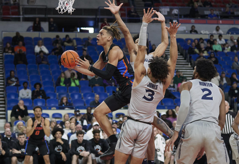 Florida guard Riley Kugel shoots in front of Xavier guard Colby Jones (3), guard Desmond Claude and forward Jerome Hunter (2) during the first half of an NCAA college basketball game in the Phil Knight Legacy tournament in Portland, Ore., Thursday, Nov. 24, 2022. (AP Photo/Craig Mitchelldyer)
