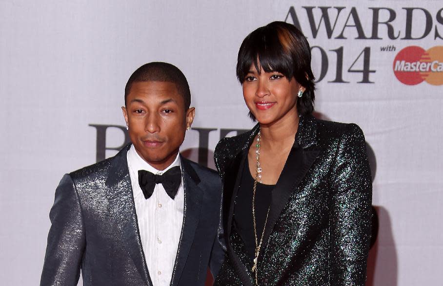 US singer-songwriter Pharrell Williams, left and his wife Helen Lasichanh arrive at the BRIT Awards 2014 at the O2 Arena in London on Wednesday, Feb. 19, 2014. (Photo by Joel Ryan/Invision/AP)