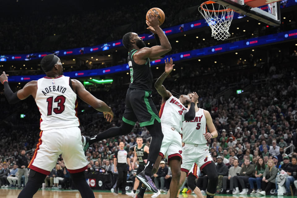 Boston Celtics guard Jaylen Brown (7) drives past Miami Heat center Bam Adebayo (13) during the first half of Game 5 of an NBA basketball first-round playoff series, Wednesday, May 1, 2024, in Boston. (AP Photo/Charles Krupa)