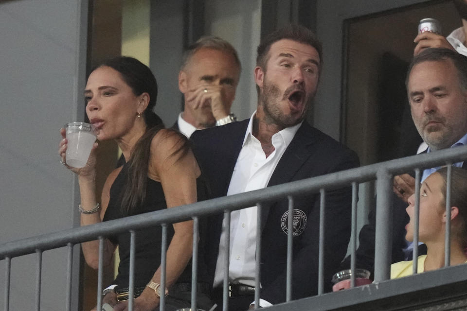 David Beckham, front center, jokes around as his wife, Victoria Beckham, sits on his lap before a Leagues Cup soccer match between Inter Miami and FC Dallas on Sunday, Aug. 6, 2023, in Frisco, Texas. (AP Photo/LM Otero)