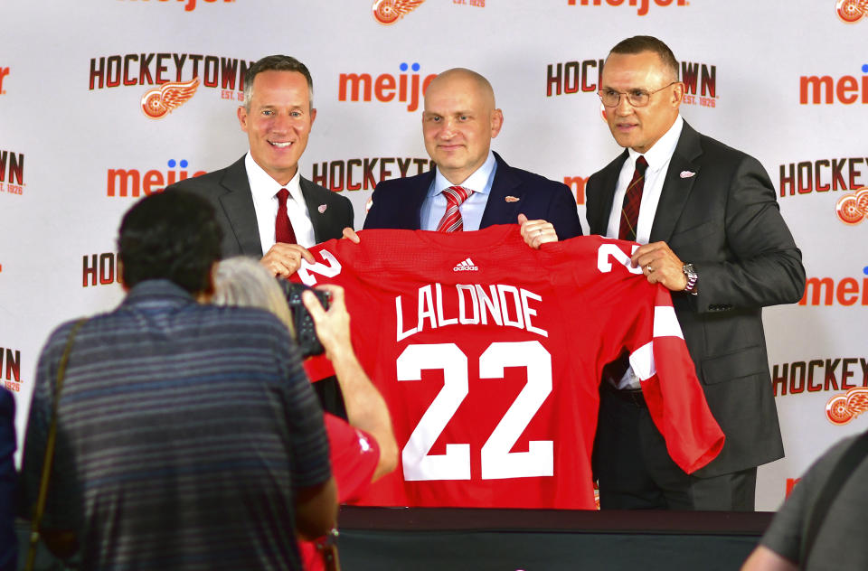 Detroit Red Wings NHL hockey team CEO Christopher Ilitch, left, poses with new Red Wings head coach Derek Lalonde, center, and Red Wings GM Steve Yzerman during an introductory news conference for Lalonde, Friday, July 1, 2022, in Detroit. (Max Ortiz/Detroit News via AP)