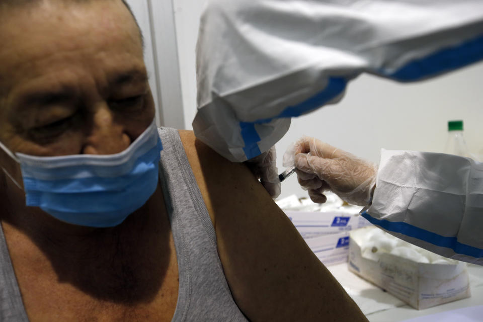 A medical worker administers a shot of COVID-19 vaccine to a man in Belgrade, Serbia, Wednesday, Feb. 17, 2021. Serbia, a country of 7 million, has so far vaccinated some 1 million people, mainly with the Chinese Sinopharm vaccine and Russian Sputnik V, and to a lesser extent with the Pfizer jab. (AP Photo/Darko Vojinovic)