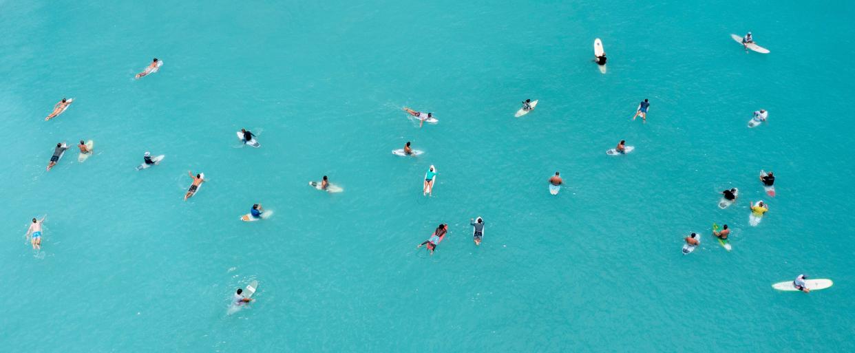 Surfers wait to catch a wave in Juno Beach, Florida on June 8, 2022. 