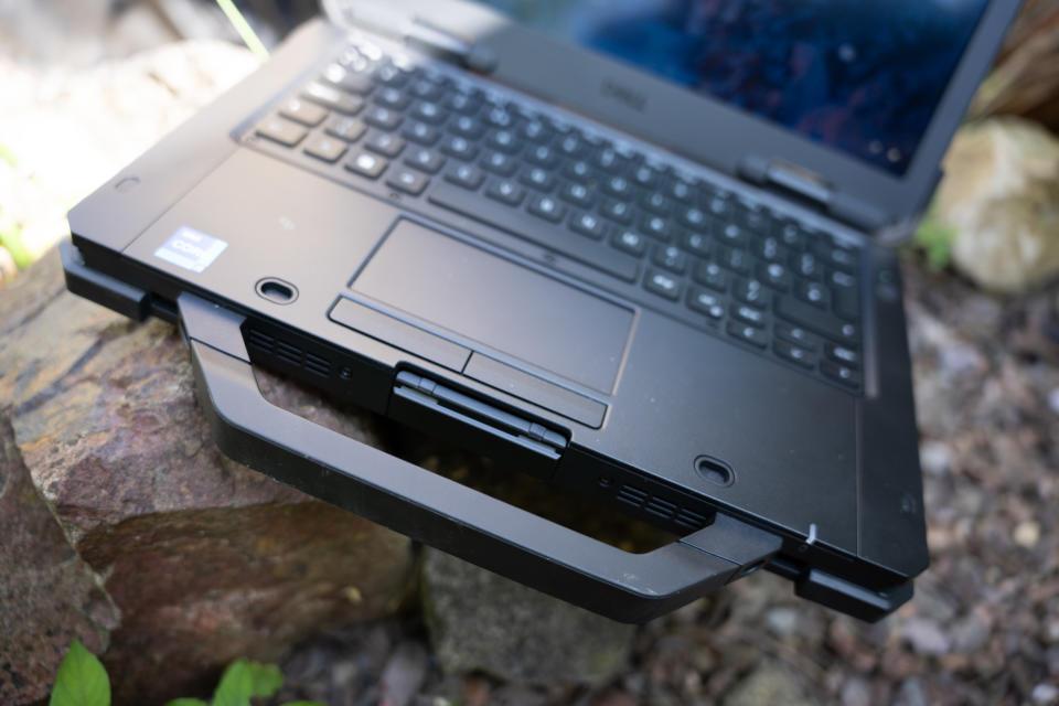 A black Dell Latitude 7330 Rugged Extreme laptop sitting on a rocky surface