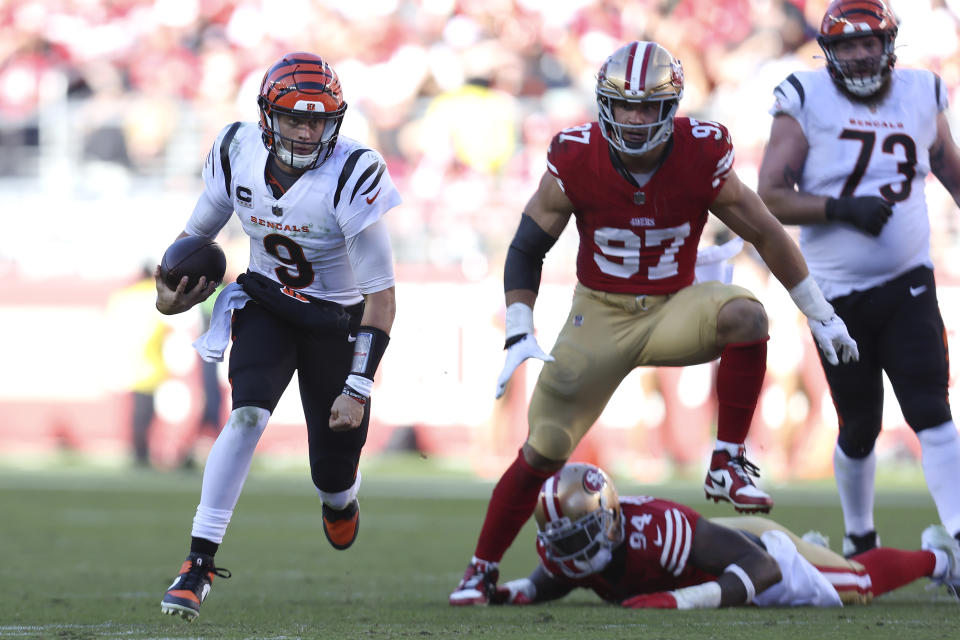 Cincinnati Bengals quarterback Joe Burrow (9) runs in front of San Francisco 49ers defensive end Nick Bosa (97) and defensive end Clelin Ferrell (94) during the second half of an NFL football game in Santa Clara, Calif., Sunday, Oct. 29, 2023. (AP Photo/Jed Jacobsohn)