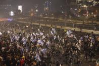 Israeli police disperse demonstrators blocking a highway during a protest against plans by Prime Minister Benjamin Netanyahu's government to overhaul the judicial system in Tel Aviv, Israel, Monday, March 27, 2023. Tens of thousands of Israelis have poured into the streets across the country in a spontaneous outburst of anger after Prime Minister Benjamin Netanyahu abruptly fired his defense minister for challenging the Israeli leader's judicial overhaul plan. (AP Photo/Oren Ziv)