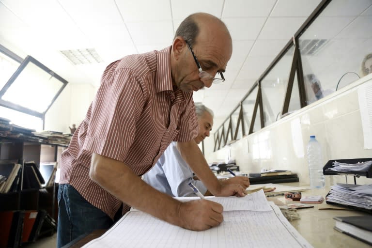 Syrian government employees record names of towns and inhabitants at the civil registry in Amuda, some 30 kilometres west of Qamishli, a Kurdish-majority city in northeastern Hasakeh province, on October 3, 2016