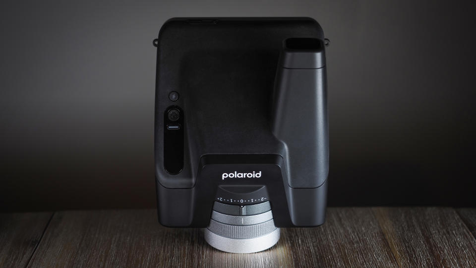 Polaroid I-2 camera on a wooden surface with dramatic lighting