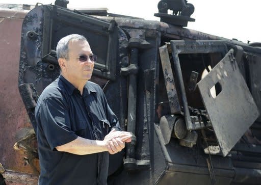 Israeli Defence Minister Ehud Barak inspects a burnt armoured vehicle near the Kerem Shalom border crossing after unidentified gunmen crossed into Israel. Egypt's army vowed Monday to "avenge" the killing of 16 troops by gunmen near the Israeli border and President Mohamed Morsi won US backing as he ordered his security forces to take full control of the Sinai