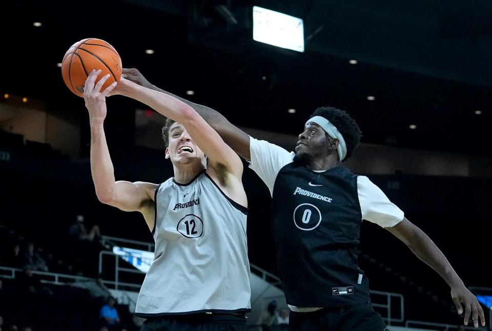 Ticket Gaines reaches over the shoulder of Eli DeLaurier as they battle for a rebound in the first half.