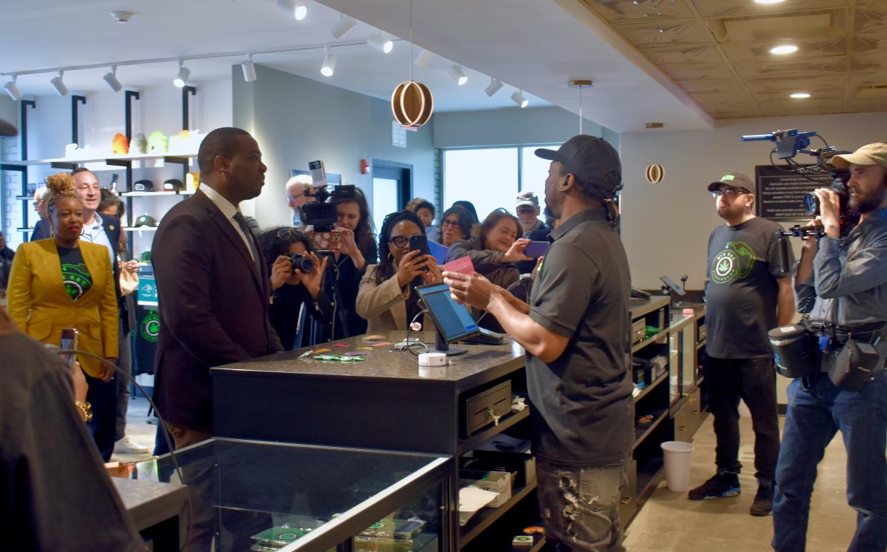 New York Office of Cannabis Management Executive Director Chris Alexander, left, makes the first purchase from owner Kareem Haynesworth, right, of Big Gas Dispensary in New Paltz on Wednesday.