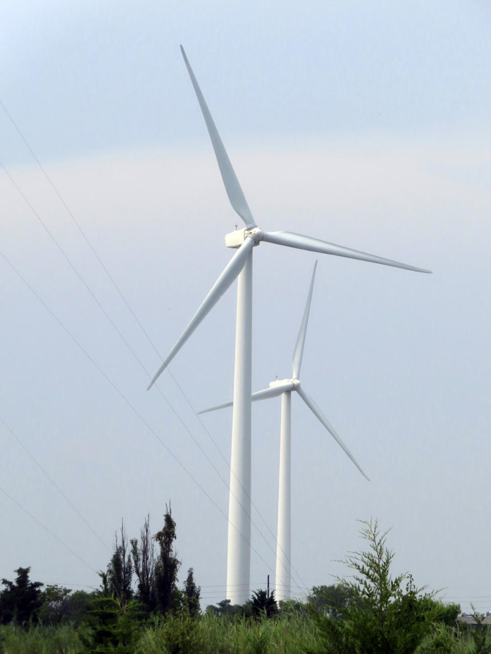 FILE - Land-based wind turbines in Atlantic City, N.J., turn on July 20, 2023. Two major offshore wind power projects are taking steps forward in New Jersey as the owners of one project agreed to bring the federal government in on their environmental monitoring plans at an earlier stage than has ever been done, and federal regulators said plans for another project are not expected to kill or seriously injure marine life. (AP Photo/Wayne Parry, File)