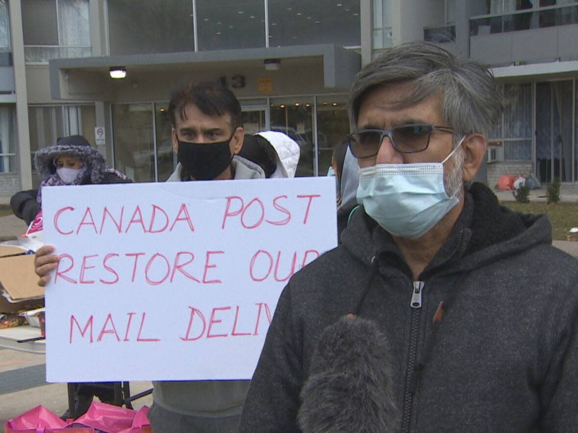 Masood Alam, right, says residents at 43 Thorncliffe Park Dr. are finding it difficult to access their mail. Canada Post suspended delivery because it says some residents who live there are not wearing masks, making it unsafe for postal workers. (CBC - image credit)