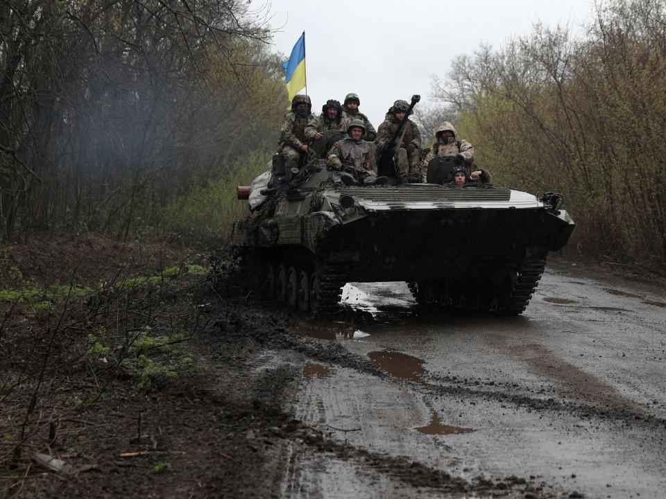 Ukrainian soldiers stand on an armoured personnel carrier (APC), not far from the front-line with Russian troops, in Izium district, Kharkiv region on April 18, 2022