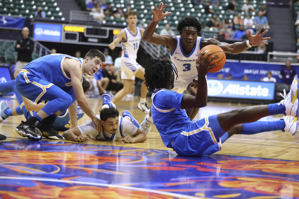 Chaminade forward Chris Bready (3) tries to stop UCLA guard Will McClendon (4) from passing the ball as UCLA guard Lazar Stefanovic (10) and Chaminade guard Jessiya Villa (4) watch during the first half of an NCAA college basketball game Tuesday, Nov. 21, 2023, in Honolulu. (AP Photo/Marco Garcia)