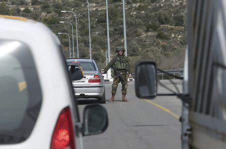 An Israeli soldier searches a Palestinian car at an Israeli checkpoint leading to the West Bank city of Ramallah February 1, 2016. REUTERS/Mohamad Torokman