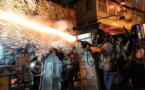 Police fire tear gas to clear pro-Democracy protesters during a demonstration on Hungry Ghost Festival day in the Sham Shui Po district - Credit: Getty