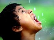 A girl quenches her thirst with water droplets from a broken pipe in the eastern Indian city of Siliguri, Thursday, March 22, 2007. World Water Day is being observed across the world Thursday. (AP Photo/Tamal Roy)