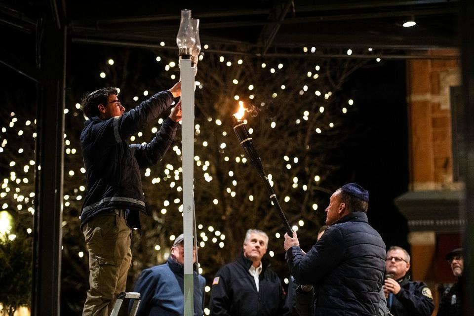Rabbi Yerachmiel Gorelik asks community members to help light the Menorah during a ceremony in Old Town Fort Collins Monday.