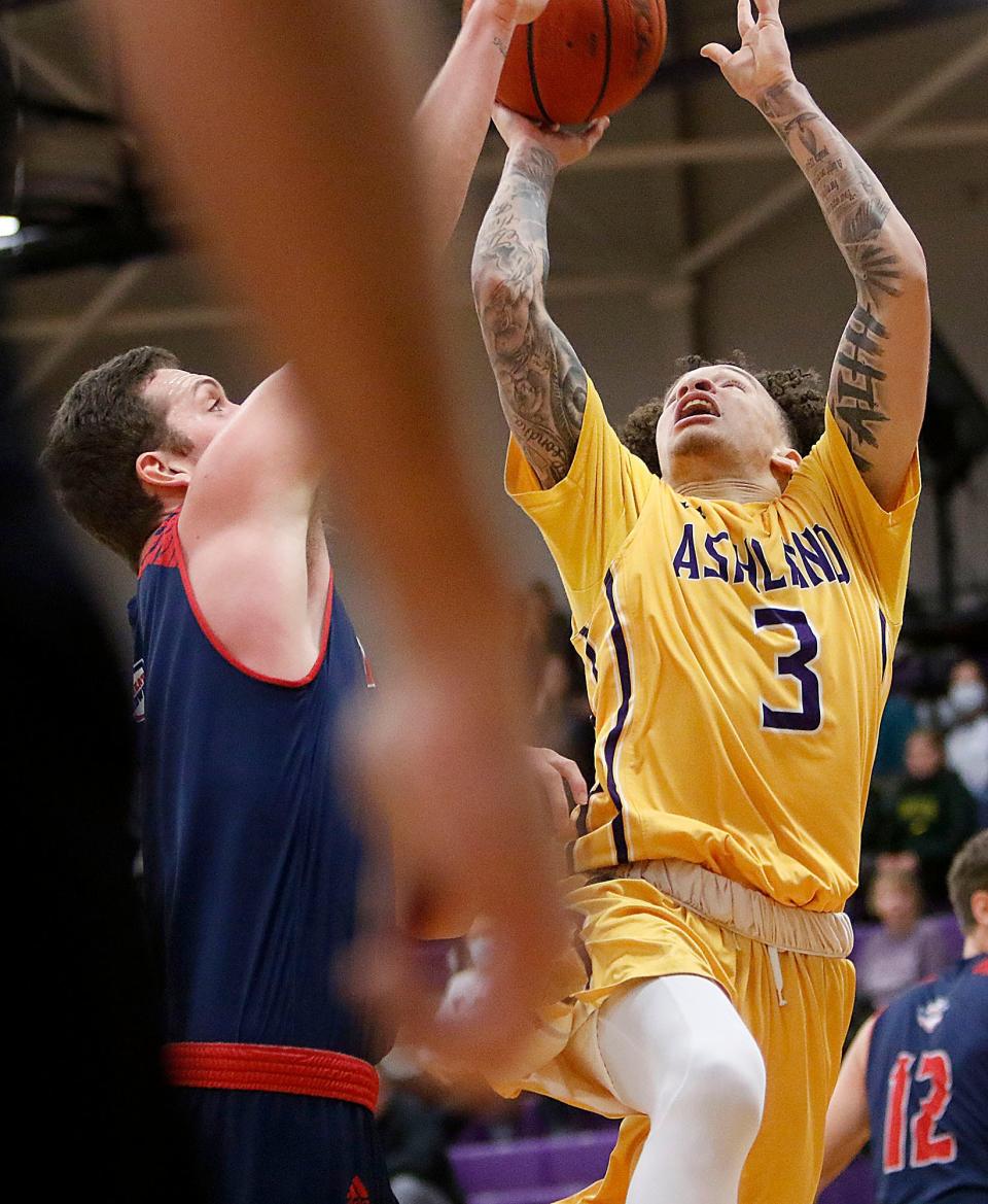 Ashland University's Tre Baumgardner (3) drives in for a shot against Malone University's Marcus Ernst during college men's basketball action Wednesday, Dec. 29, 2021 at Kates Gymnasium. TOM E. PUSKAR/TIMES-GAZETTE.COM