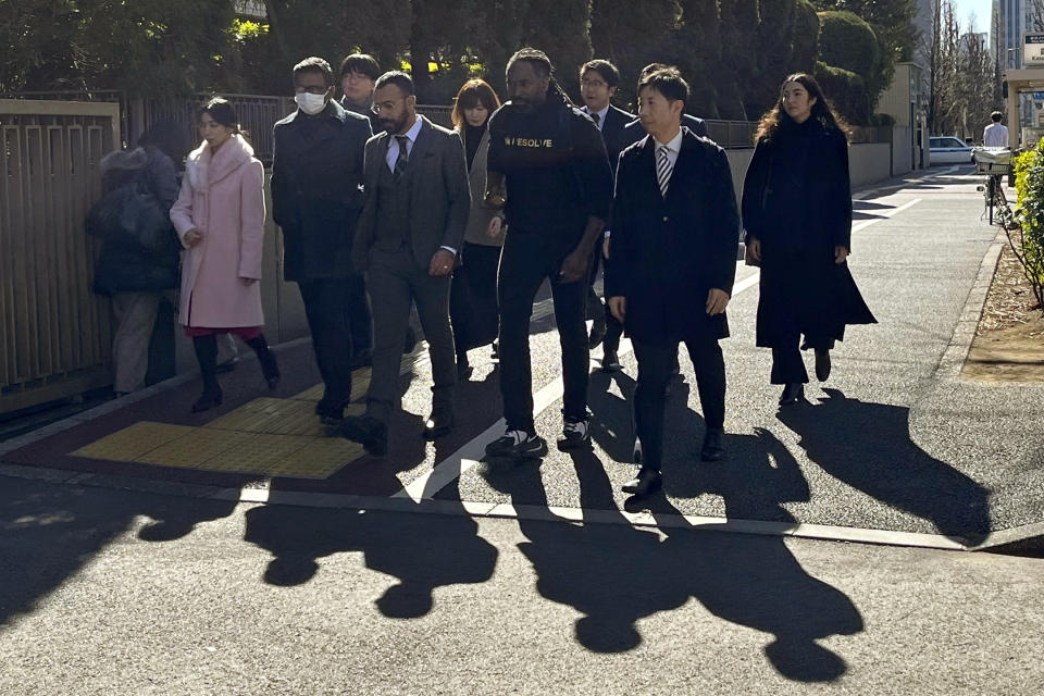 The plaintiffs and their legal team arrive at the Tokyo District Court, to file a lawsuit in Tokyo Monday, Jan. 29, 2024. A civil lawsuit filed Monday in the Japanese court is demanding an end to what it calls racial profiling by police.(AP Photo/Yuri Kageyama)