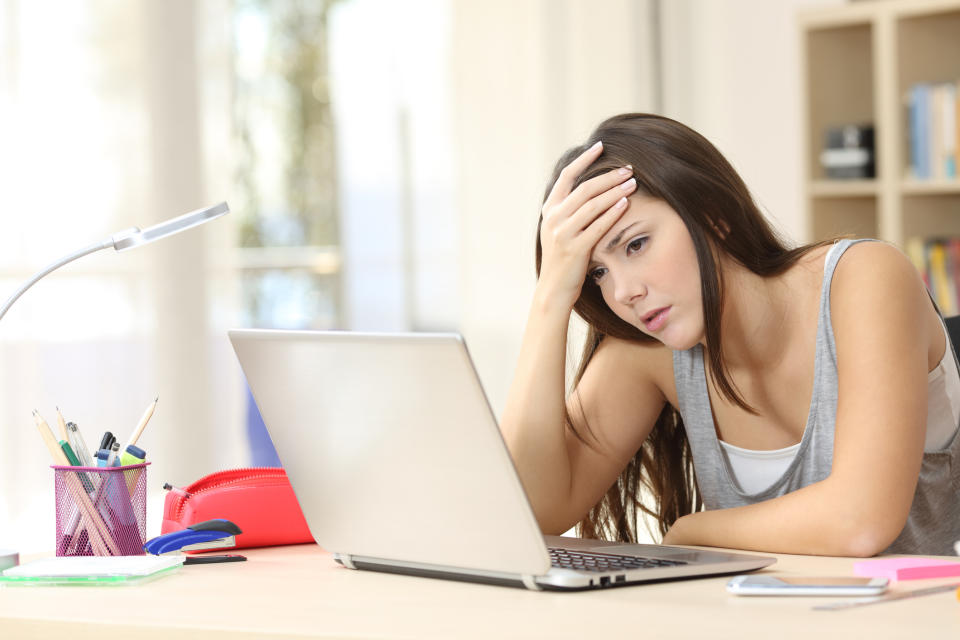 A worried woman sitting in front of her notebook computer.