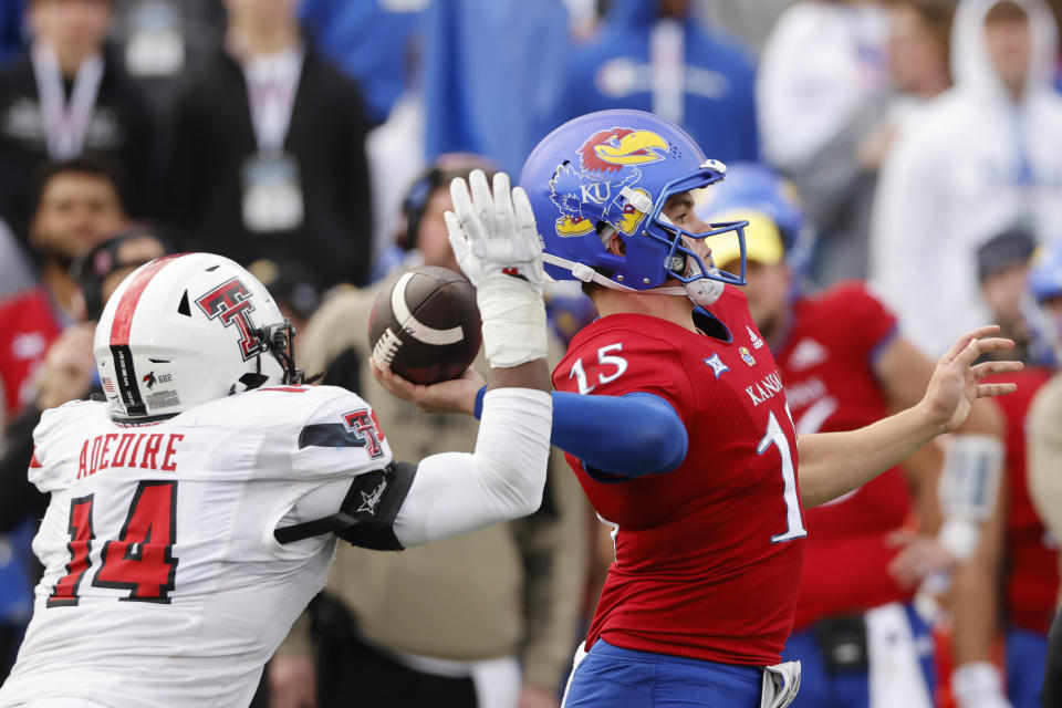 Texas Tech linebacker Joseph Adedire (14) moves in to block a pass by Kansas quarterback Cole Ballard (15) in the final play of an NCAA college football game, Saturday, Nov. 11, 2023, in Lawrence, Kan. Texas Tech defeated Kansas 16-13. (AP Photo/Colin E Braley)