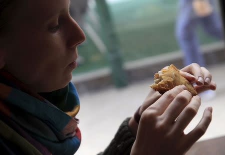 A guest eats "bolani" with fresh "laban", also known as Afghan pie with Syrian cream cheese, in the Manga Cowboy restaurant in Budapest, Hungary, September 29, 2015. REUTERS/Bernadett Szabo