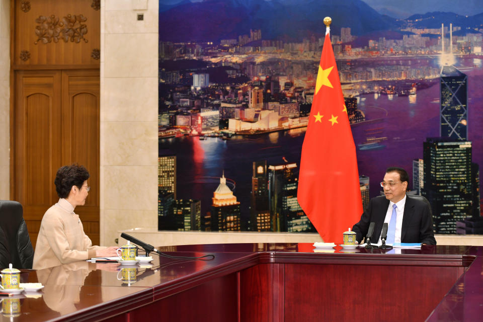 In this photo released by Hong Kong Government Information Services, Hong Kong Chief Executive Carrie Lam, left, talks with Chinese Premier Li Keqiang during a meeting in Beijing Monday, Dec. 16, 2019. Turmoil over amendments to extradition legislation has damaged Hong Kong society on all fronts, Li said Monday during a meeting with the semiautonomous territory's leader. It's her first visit to Beijing since pro-democracy candidates swept local Hong Kong elections last month in a rebuke of how Lam has handled months of fiery anti-government protests. (Hong Kong Government Information Services via AP)