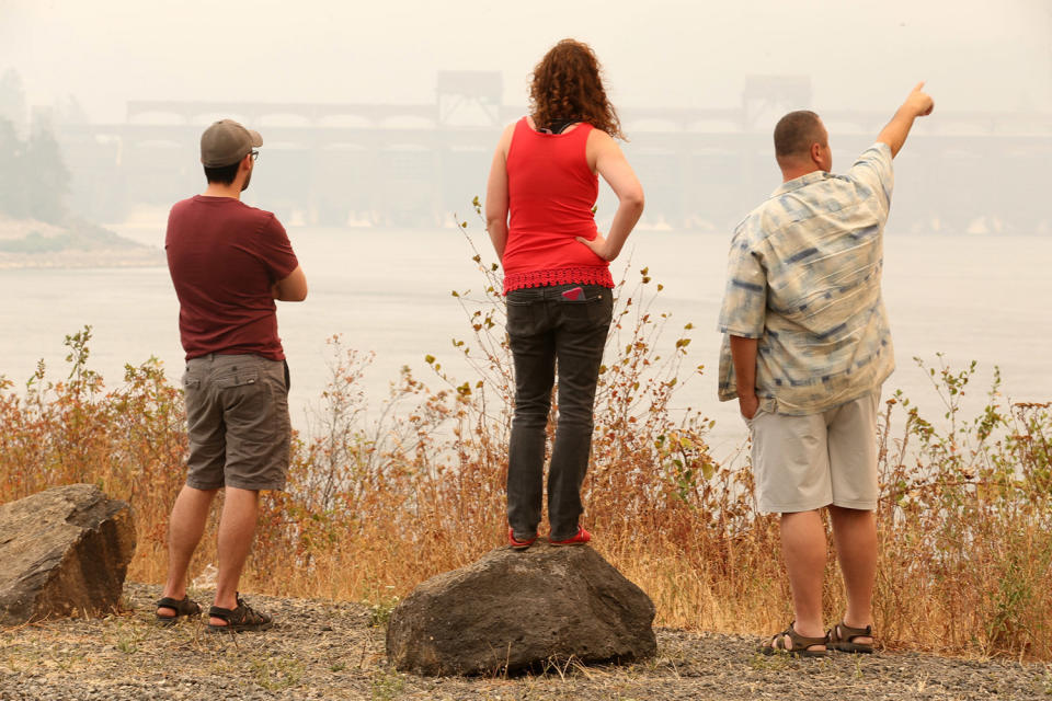 <p>People check out the smoky view of the Eagle Creek fire from North Bonneville Dam and Beacon Rock in the Columbia River Gorge on , Sept. 5, 2017. Fire officials say an Oregon wildfire in the scenic Columbia River Gorge has grown to nearly 16 square miles and is threatening homes. Residents of about 400 homes have been forced to evacuate, while others have been warned to get ready. (Photo: Mark Graves/The Oregonian via AP) </p>