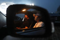 People sit in their car as they watch the Stage X drive-in concert at KINTEX parking lot in Goyang, South Korea, Saturday, May 23, 2020. The concert's aim is to provide entertainment for South Korean citizens who have been craving for music events that have been suspended during the coronavirus outbreak. (AP Photo/Ahn Young-joo)