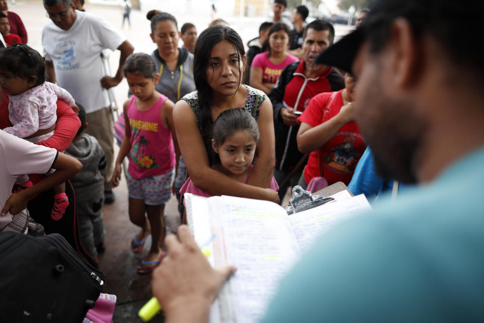 A woman from the Mexican state of Michoacan who did not give her name stands with her daughter as names are read off a list of people who will cross into the United States to begin the process of applying for asylum Thursday, July 26, 2018, near the San Ysidro port of entry in Tijuana, Mexico. As the Trump administration faced a court-imposed deadline Thursday to reunite thousands of children and parents who were forcibly separated at the U.S.-Mexico border, asylum seekers continue to arrive to cities like Tijuana, hoping to plead their cases with U.S. authorities. (AP Photo/Gregory Bull)