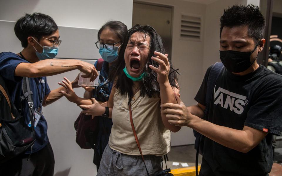 A woman reacts after being doused with pepper spray by police in Hong Kong - AFP Contributor#AFP/AFP