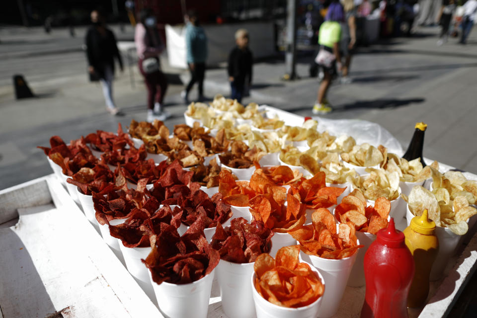 Snacks are displayed for sale in disposable cups, on the cart of a street vendor in central Mexico City, Friday, Jan. 1, 2021. The few street food vendors out working on New Year's Day amid the COVID-19 pandemic said they were either unaware of or were still figuring out how to comply with a broad ban on single-use containers, forks, straws, and other ubiquitous items that took effect Friday in Mexico's capital, one of the world's largest cities, after more than a year of preparation. (AP Photo/Rebecca Blackwell)