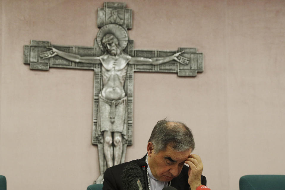 FILE - In this Friday, Sept. 25, 2020 file photo, Cardinal Angelo Becciu looks down as he meets the media during a press conference in Rome. The Vatican cardinal sacked by Pope Francis amid a corruption investigation is fighting back, suing an Italian newsmagazine and claiming that his ouster has deprived him of the chance of being pope and will undermine the legitimacy of a future papal election. Cardinal Angelo Becciu is seeking 10 million euros in damages, to be given to charity, in a complaint filed in the Sassari, Sardinia tribunal against L’Espresso, the weekly magazine of Italy’s La Repubblica daily. (AP Photo/Gregorio Borgia, File)