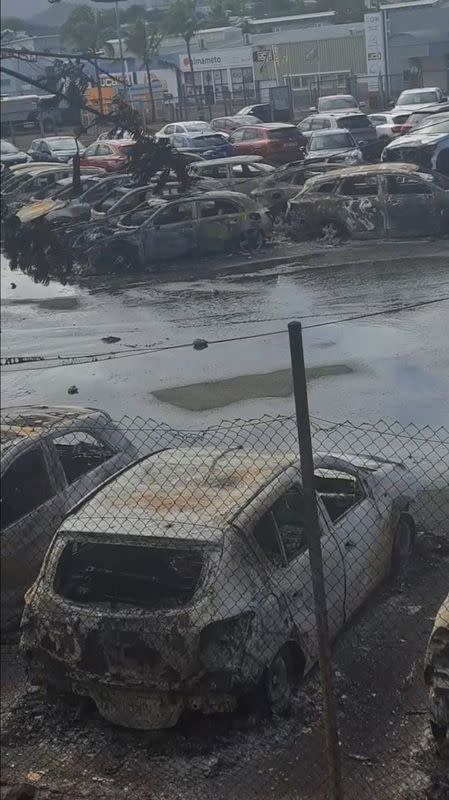 Burnt cars in the aftermath of protests that turned violent, in Noumea