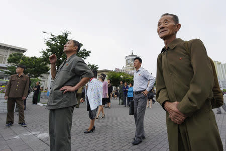 North Korean watch news report on North Korea's leader Kim Jong Un's Singapore visit in front of an electronic screen at Pyongyang station in Pyongyang, North Korea, in this photo taken by Kyodo June 11, 2018. Mandatory credit Kyodo/via REUTERS A