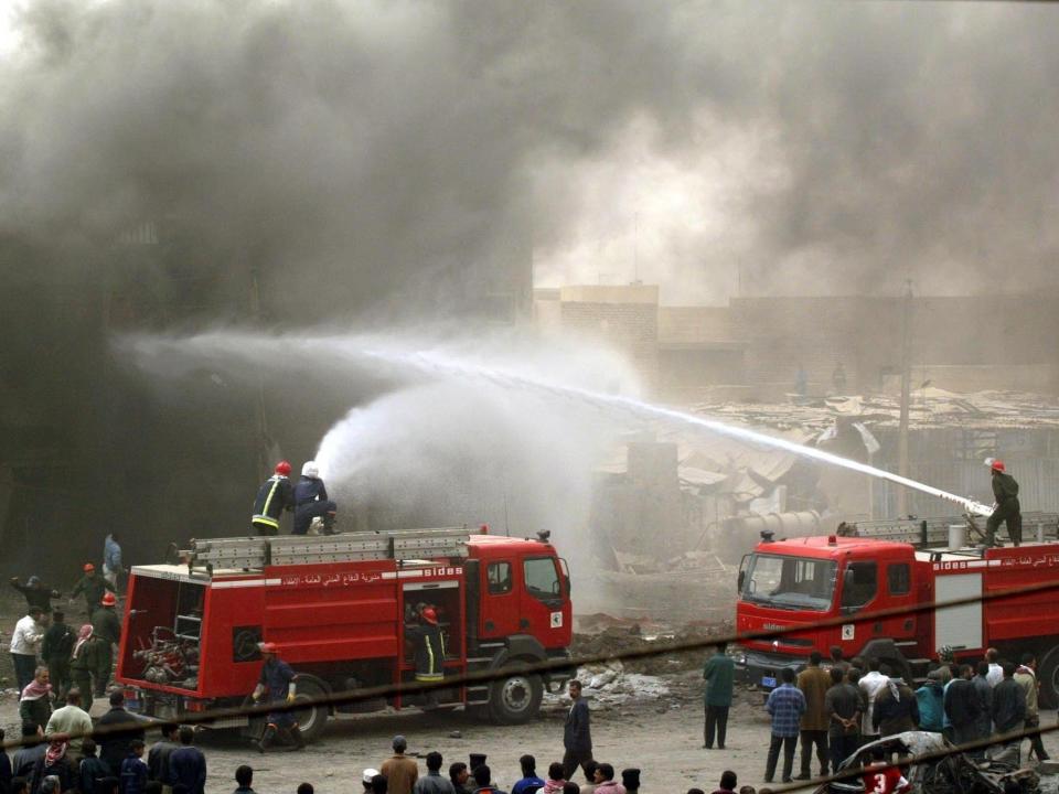 <p>Iraqi firefighters tackle a burning building after the airstrike in Baghdad</p>Goran Tomasevic/Reuters