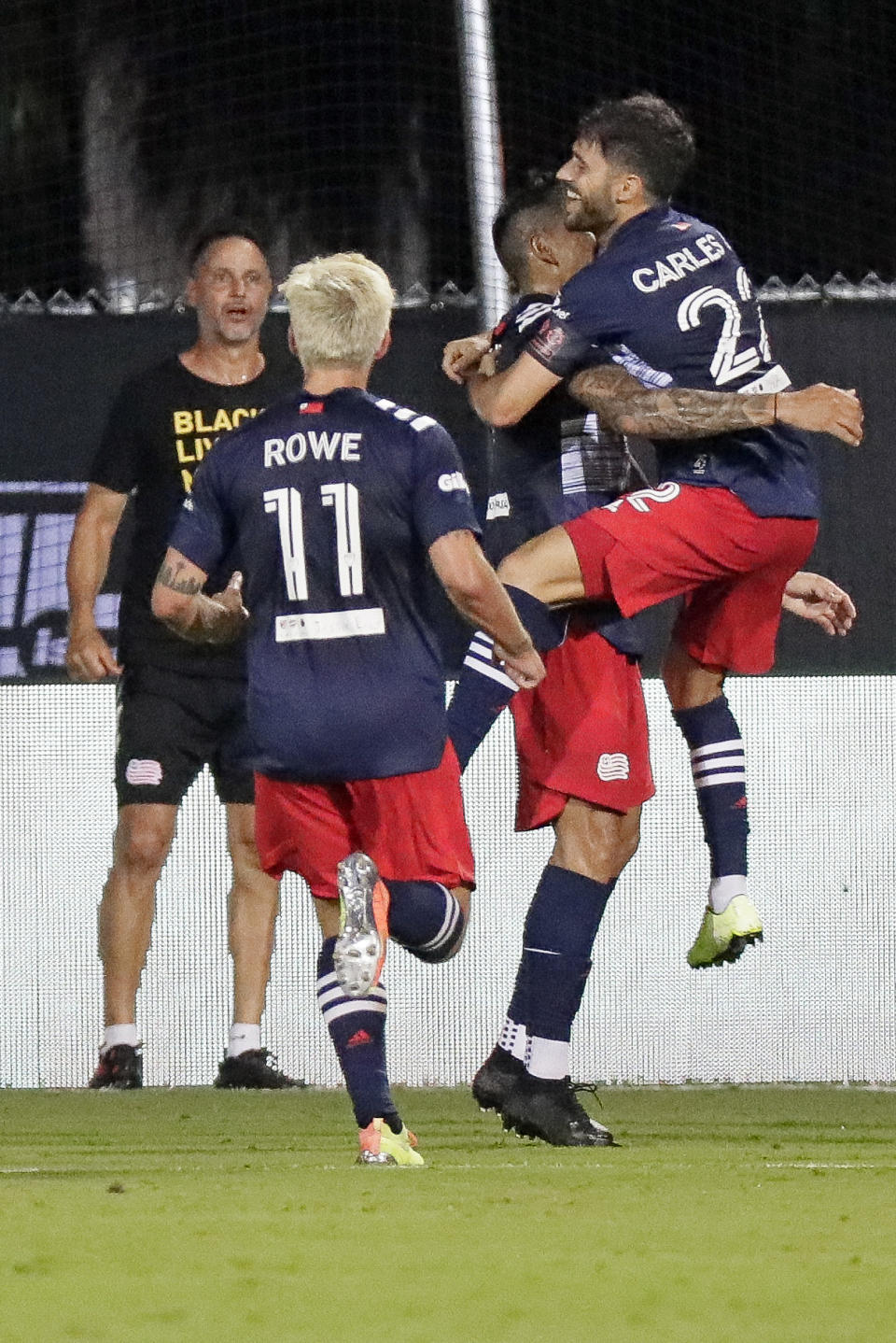 Carles Gil, right, jumps into the arms of Gustavo Bou after Bou scored a goal against the Montreal Impact as Kelyn Rowe (11) joins the celebration during the second half of an MLS soccer match Thursday, July 9, 2020, in Kissimmee, Fla. (AP Photo/John Raoux)