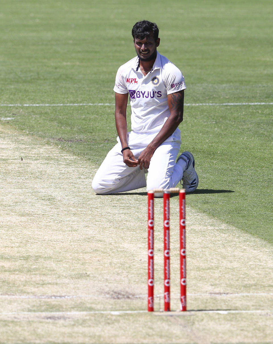 India's Thangarasu Natarajan rests on the pitch during play on day two of the fourth cricket test between India and Australia at the Gabba, Brisbane, Australia, Saturday, Jan. 16, 2021. (AP Photo/Tertius Pickard)