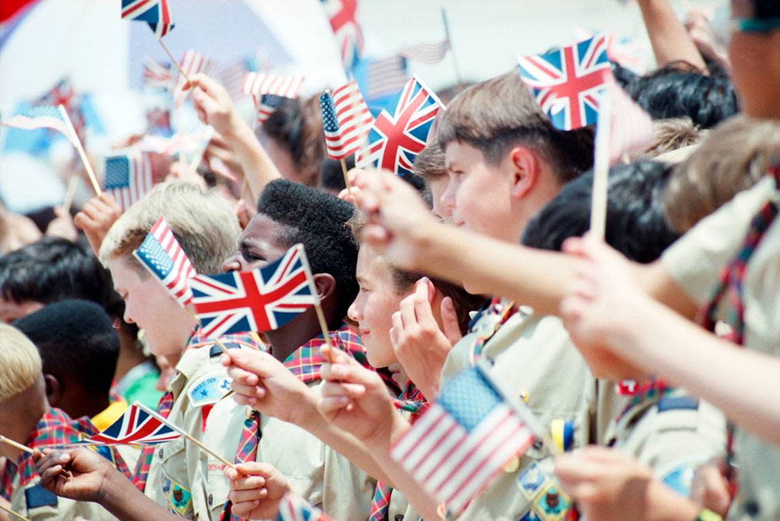 Boy Scouts wave British and American flags upon the arrival of Queen Elizabeth II at Love Field on May 21, 1991.