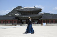 FILE - In this April 23, 2020 file photo, women wearing masks as a precaution against the new coronavirus, walk at the Gyeongbok Palace, in Seoul, South Korea. Nervous travelers, spotty air service, health risks _ the battered global tourism industry is facing unprecedented uncertainty in the wake of the new coronavirus. Millions of workers are laid off or furloughed, and it will likely take years for the industry to get back to the strong demand it was seeing just six months ago. (AP Photo/Lee Jin-man, File)