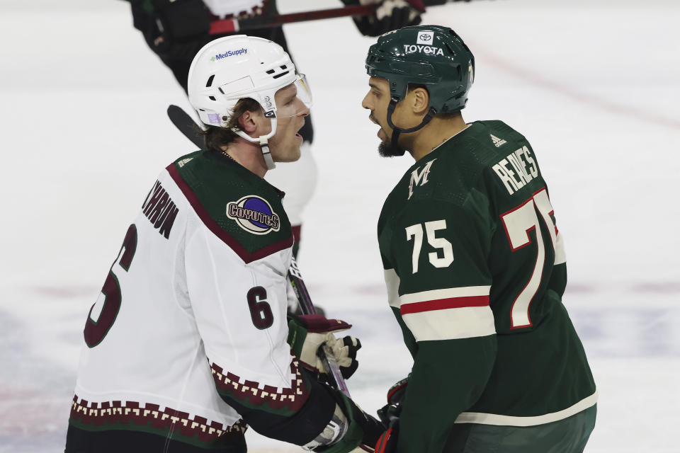 Arizona Coyotes defenseman Jakob Chychrun (6) and Minnesota Wild right wing Ryan Reaves (75) exchange words during the second period of an NHL hockey game, Sunday, Nov. 27, 2022, in St. Paul, Minn. (AP Photo/Stacy Bengs)