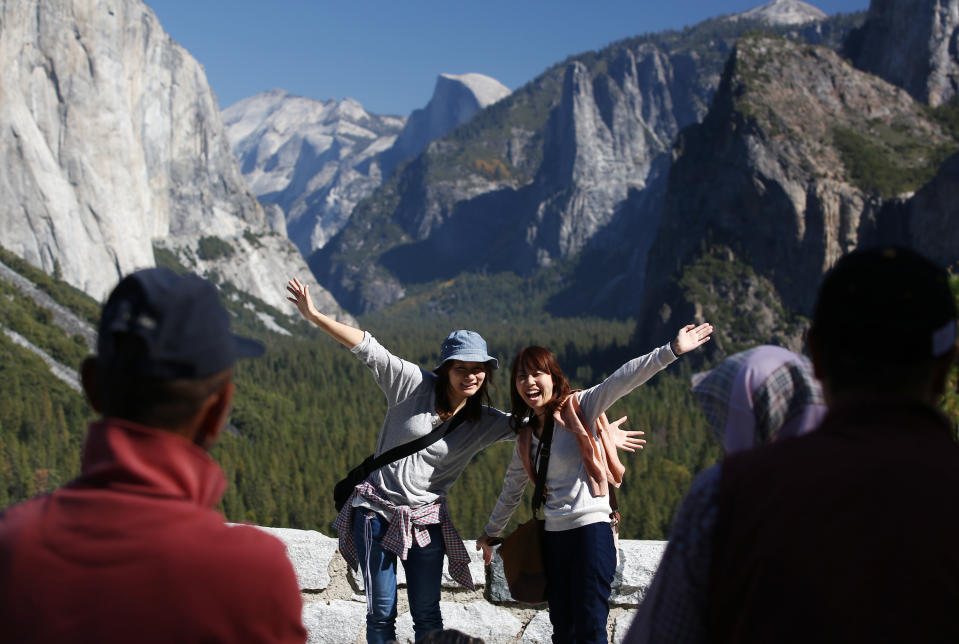 Visitors at Tunnel View, like Kaori Nishimura and Eriko Kuboi, from Japan, pose in front of Half Dome, center facing, during the reopening of Yosemite National Park, Calif., Thursday, Oct. 17, 2013. Tunnel View is a scenic vista which shows off El Capitan, Half Dome and Bridalveil Fall. The park reopened Wednesday night with the end of the 16-day partial government shutdown. (AP Photo/Gary Kazanjian)